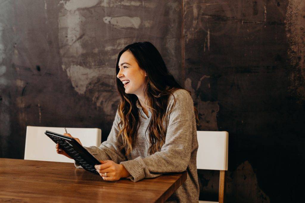 woman smiling on tablet