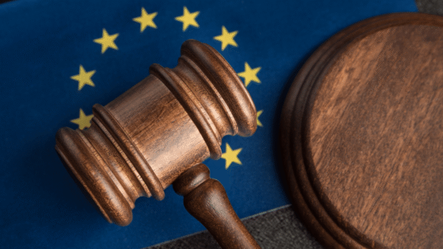 Houten hamer en voetstuk op de Europese vlag, symbool voor EU-wetgeving zoals de AI Act